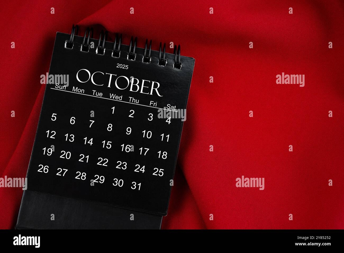 October 2025 Black Spiral Desktop Calendar On Red Textile Background Stock Photo Alamy